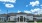 a large white building with a blue sky and clouds
