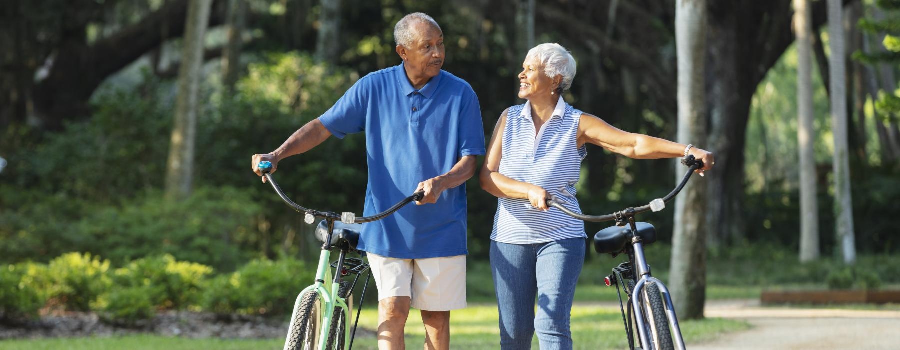 a man and woman walking with a bicycle