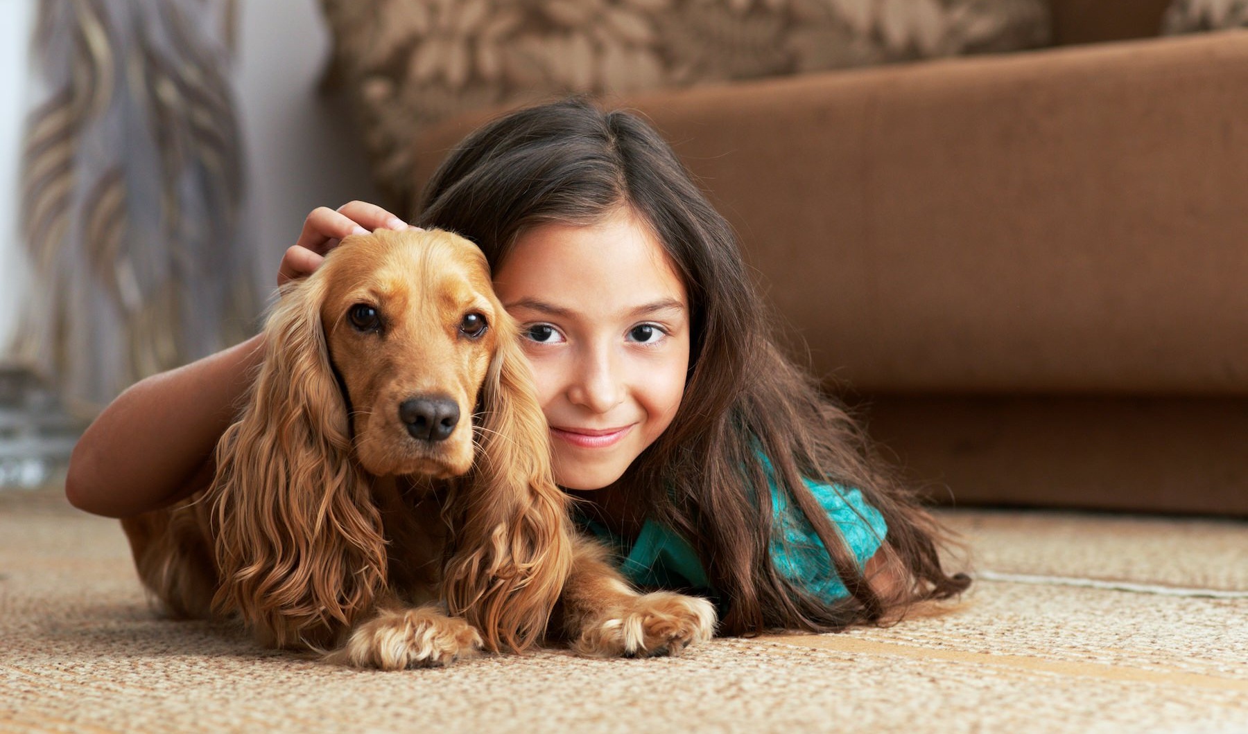 a girl and a dog laying on the ground