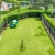 a lawn with a fence and cars parked on the side